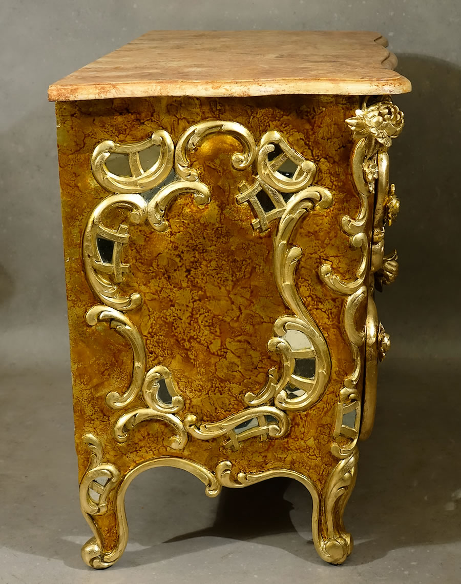 Côtés de la commode rococo ornés de miroirs dans des réserves sculptées en parcloses